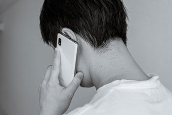 スマホをする男性白黒画像